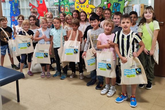 Die Kinder einer 2. Klasse der Grundschule Losheim nehmen ihre Fairen Taschen in Empfang. Foto: Caroline Wein